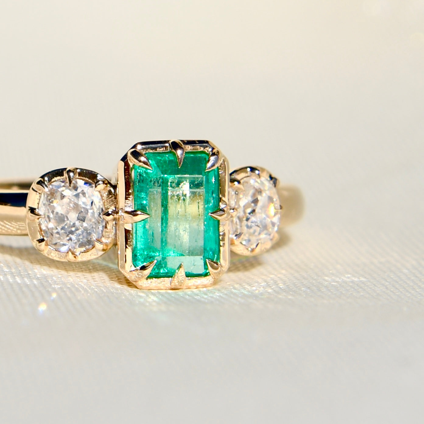 0.93 ct Colombian emerald and old mine cut diamond three stone ring