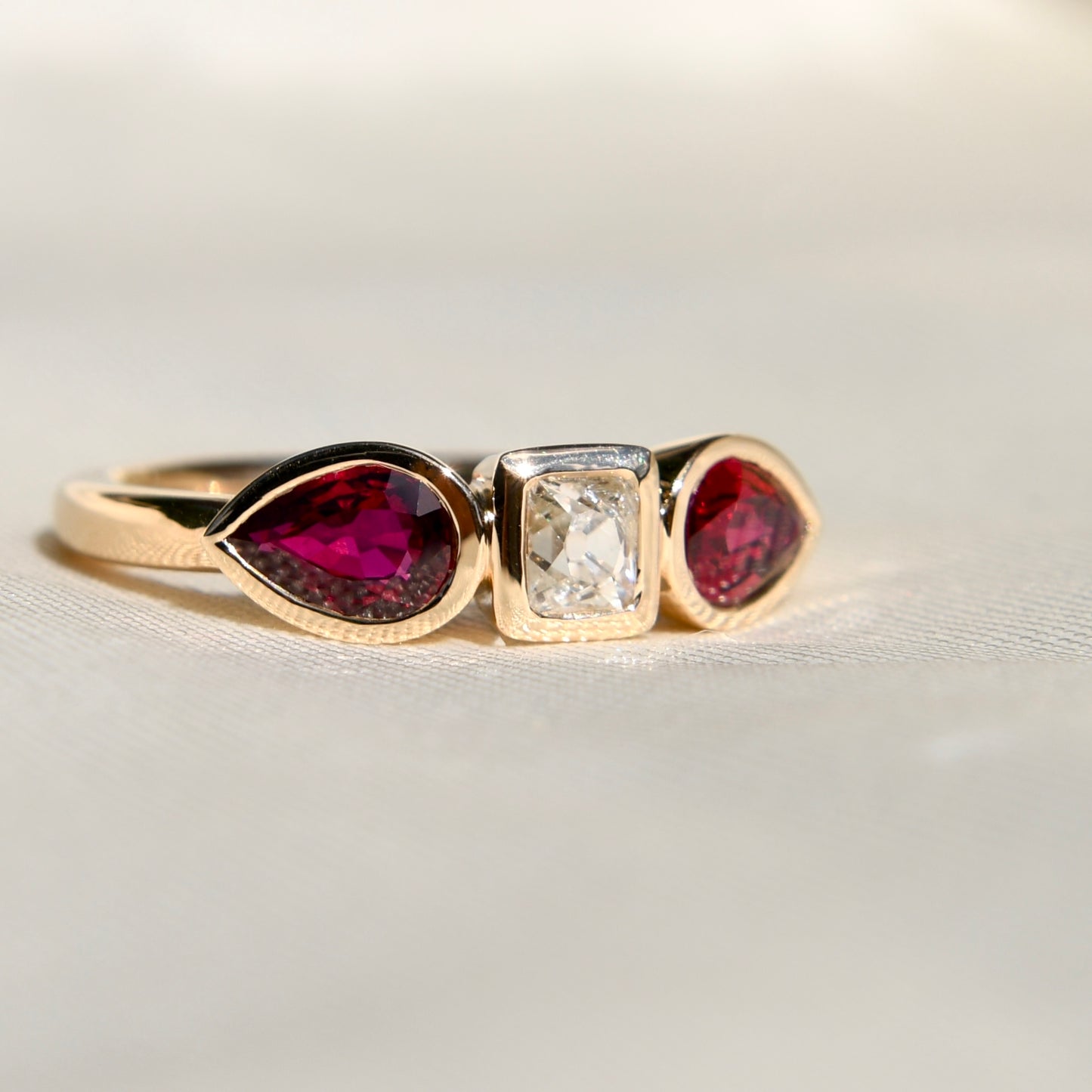 0.30 ct peruzzi cut diamond and pear ruby three stone ring