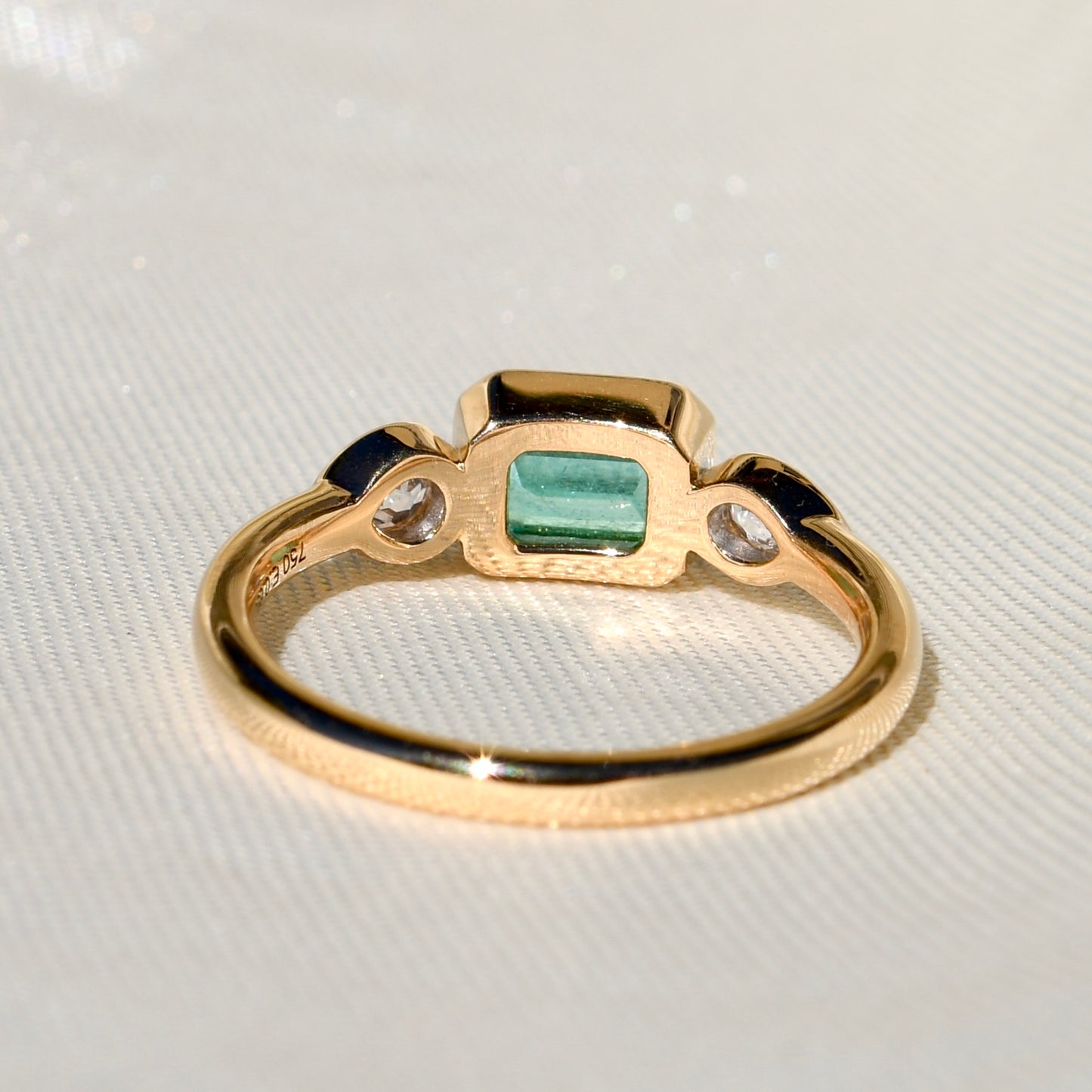 0.69 ct Colombian emerald and old pear cut diamond three stone ring