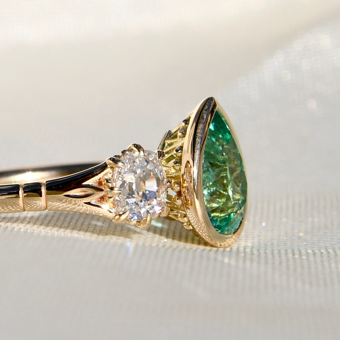 1.34 ct Colombian pear cut emerald and old mine cut diamond three stone ring